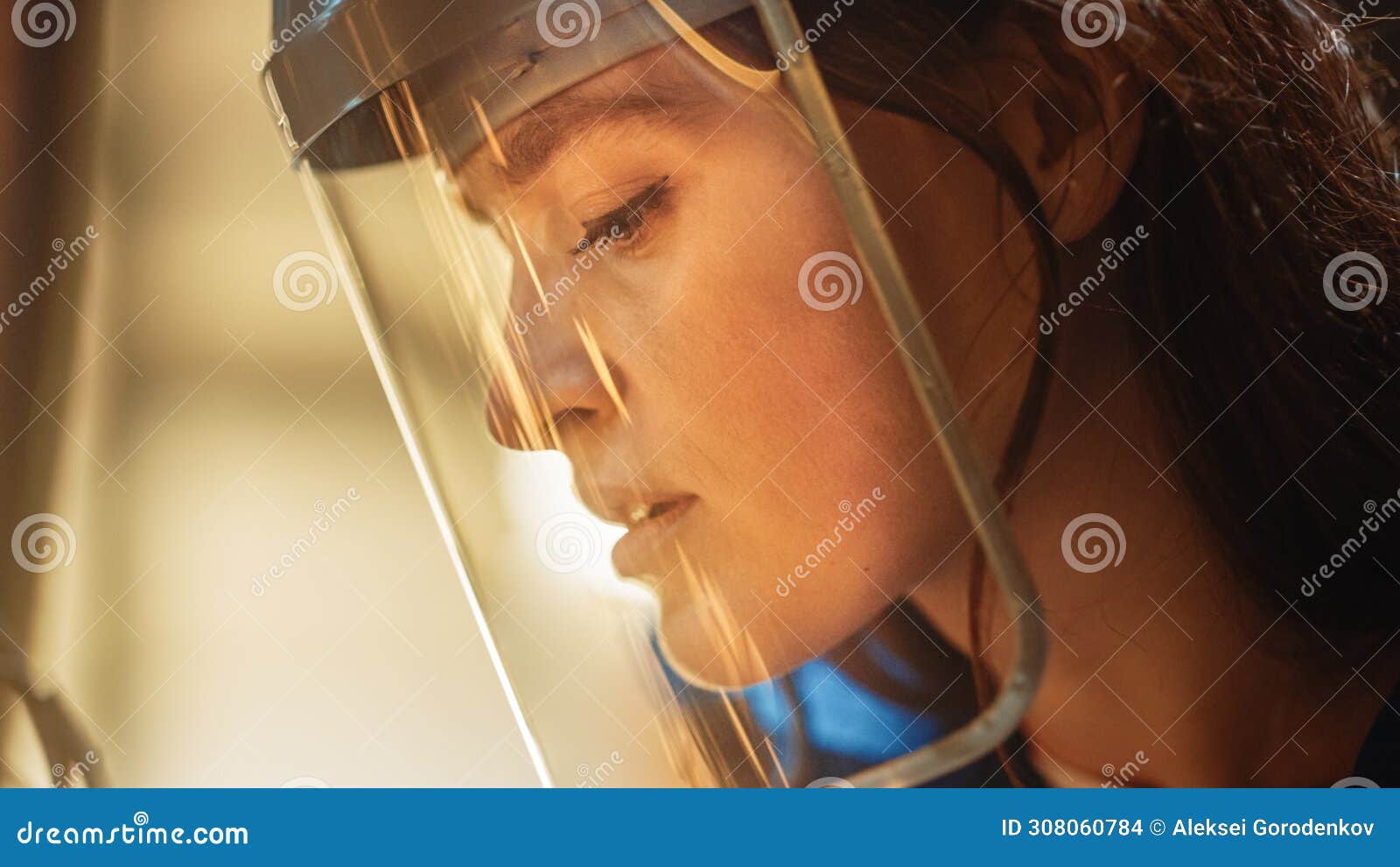 close up portrait of beautiful female fabricator in safety mask. she is grinding a metal object. e