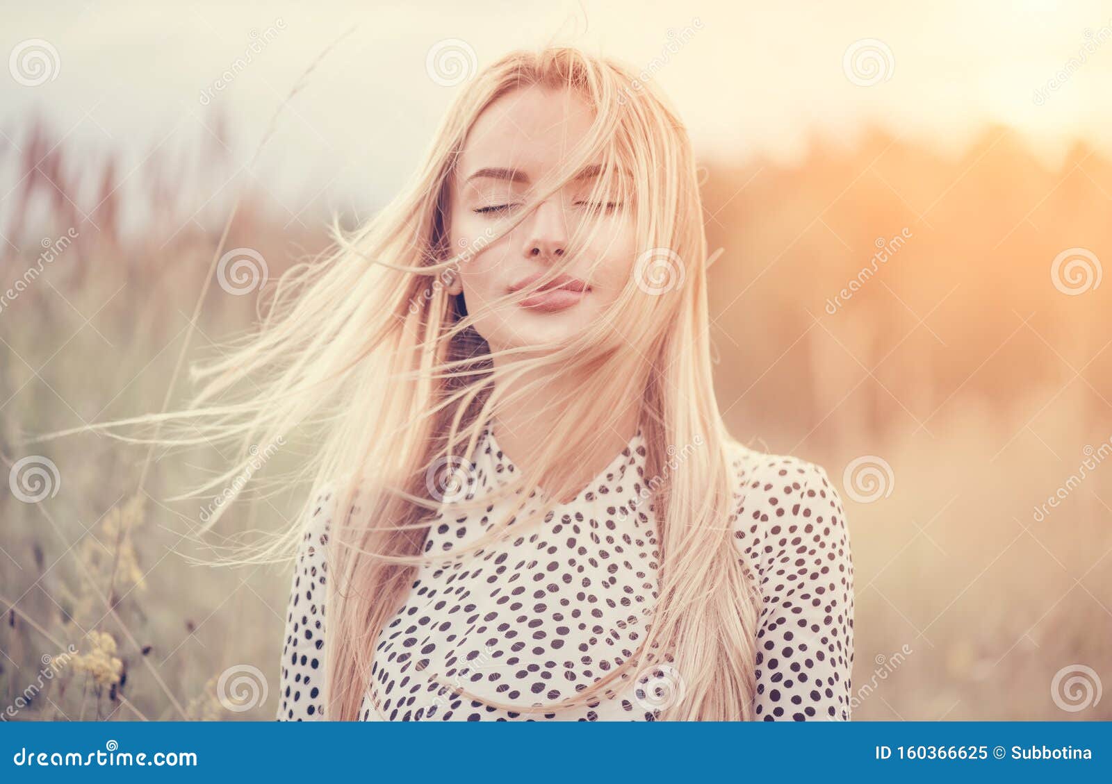 close up portrait of beauty girl with fluttering white hair enjoying nature outdoors, on a field. flying blonde hair on the wind