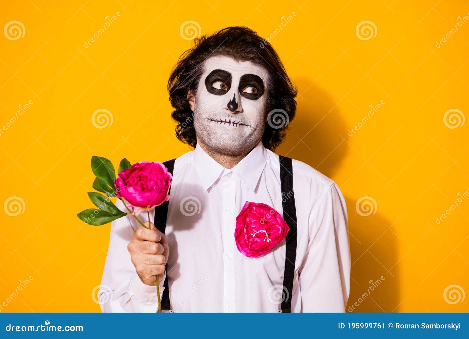 close-up portrait of handsome creepy baleful shy cheery guy holding in hand single natural fresh rose blooming blossom