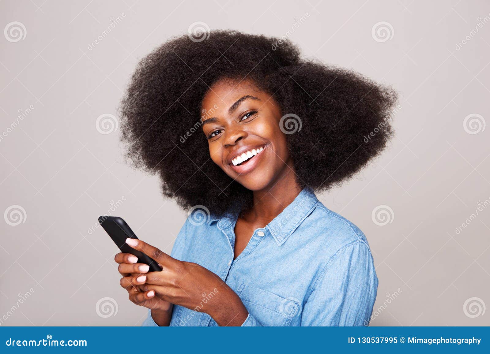 close up portrait of happy young african american woman smiling with mobile phone
