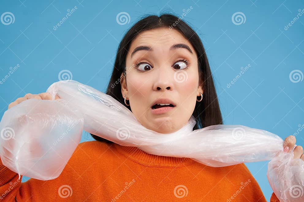 Close Up Portrait of Korean Woman Being Choked by Large Plastic Bag