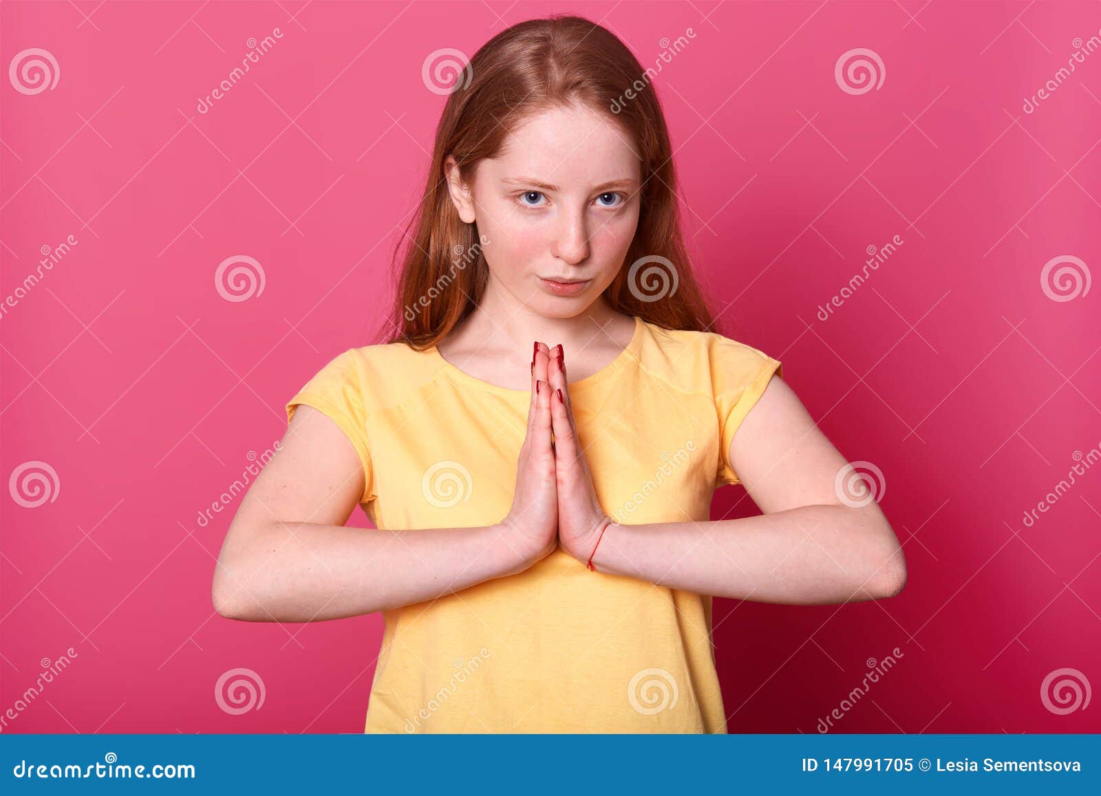 close up portrait of serious beautiful caucasian female posing in studio, looks directly at camera with confident expresion, keeps