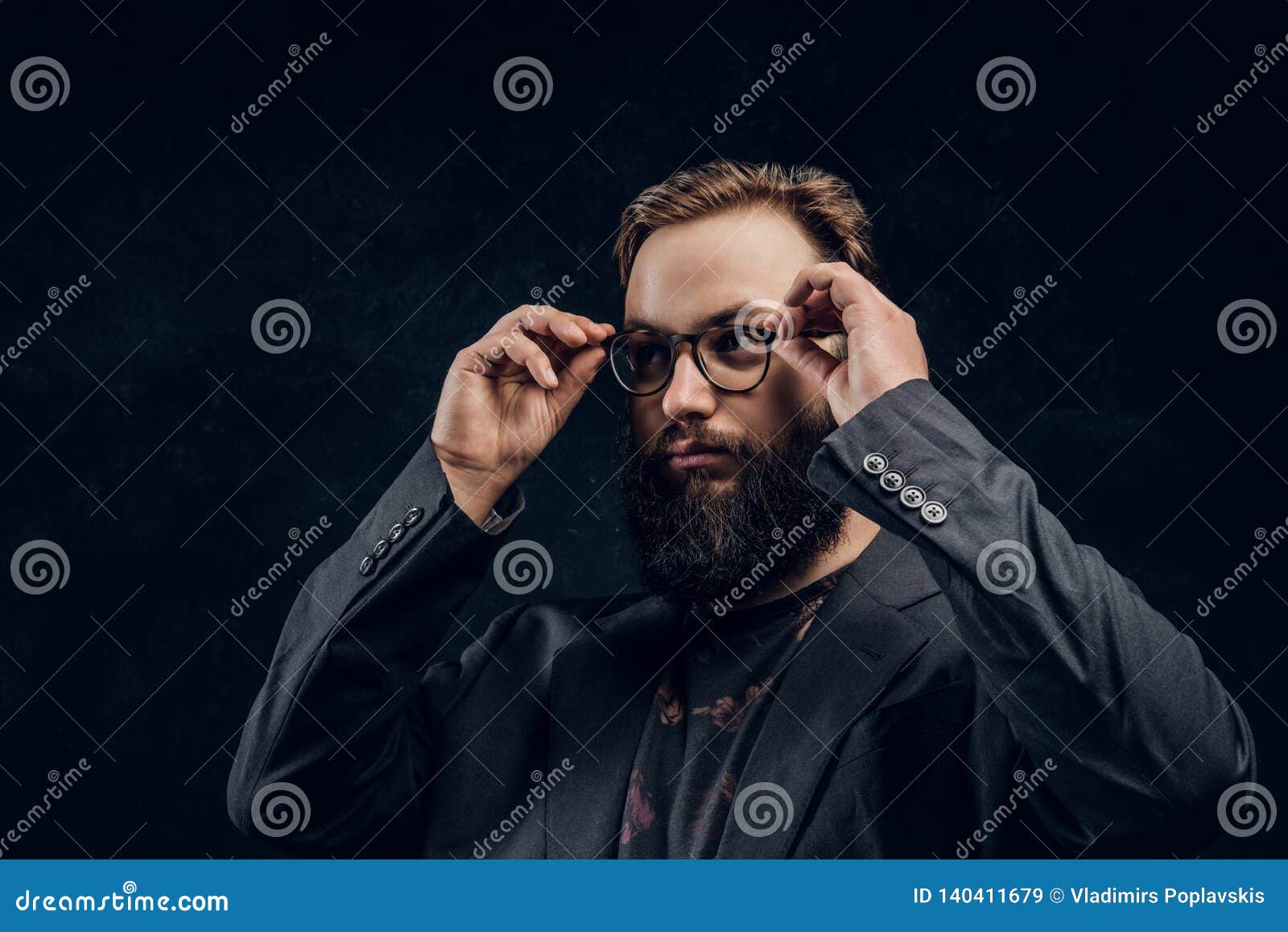 Close-up Portrait of a Smart Bearded Guy in a Black Jacket Corrects His ...