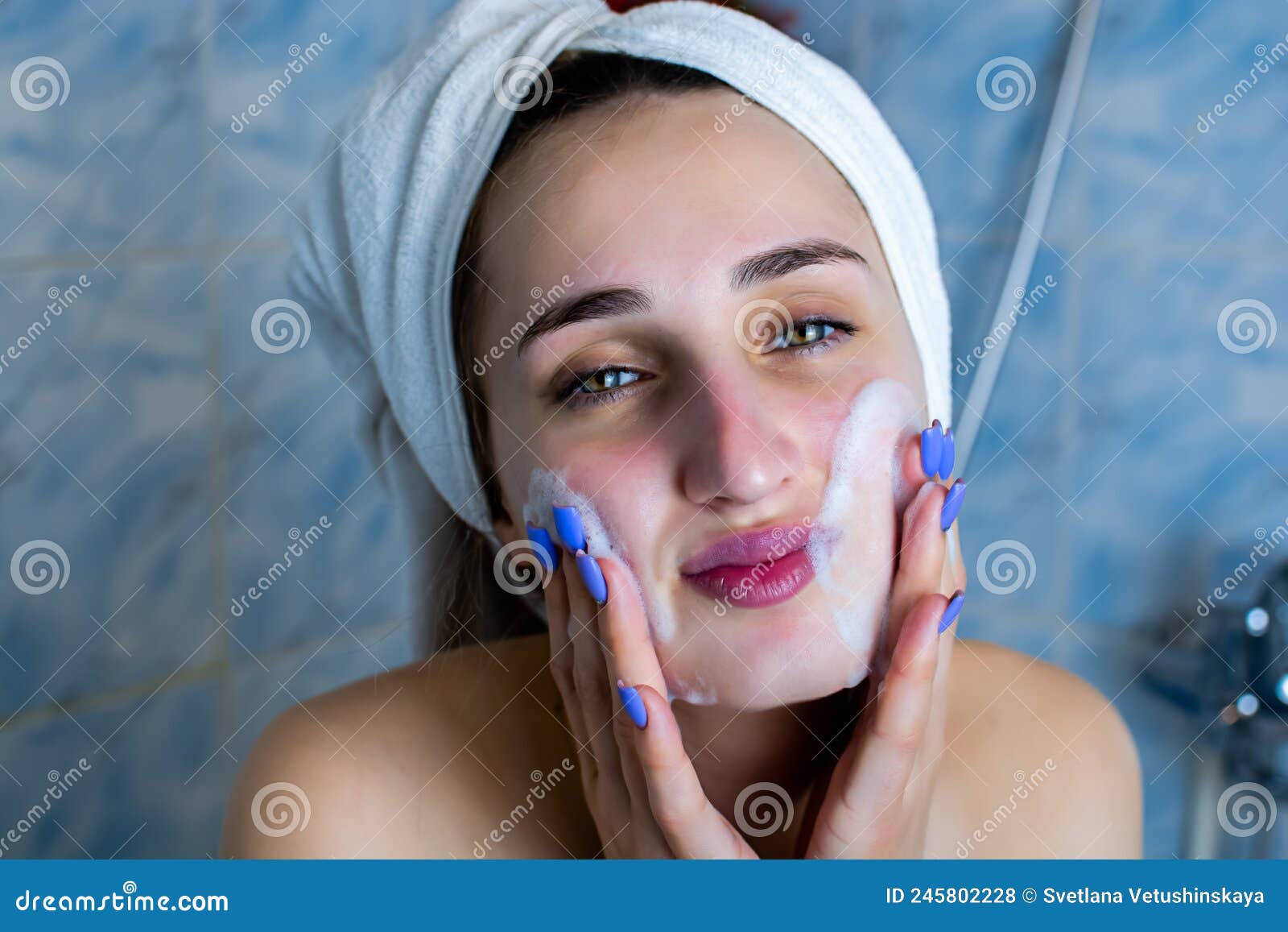 Close Up Portrait Of Smiling Brunette Girl Cleaning Her Cheeks With