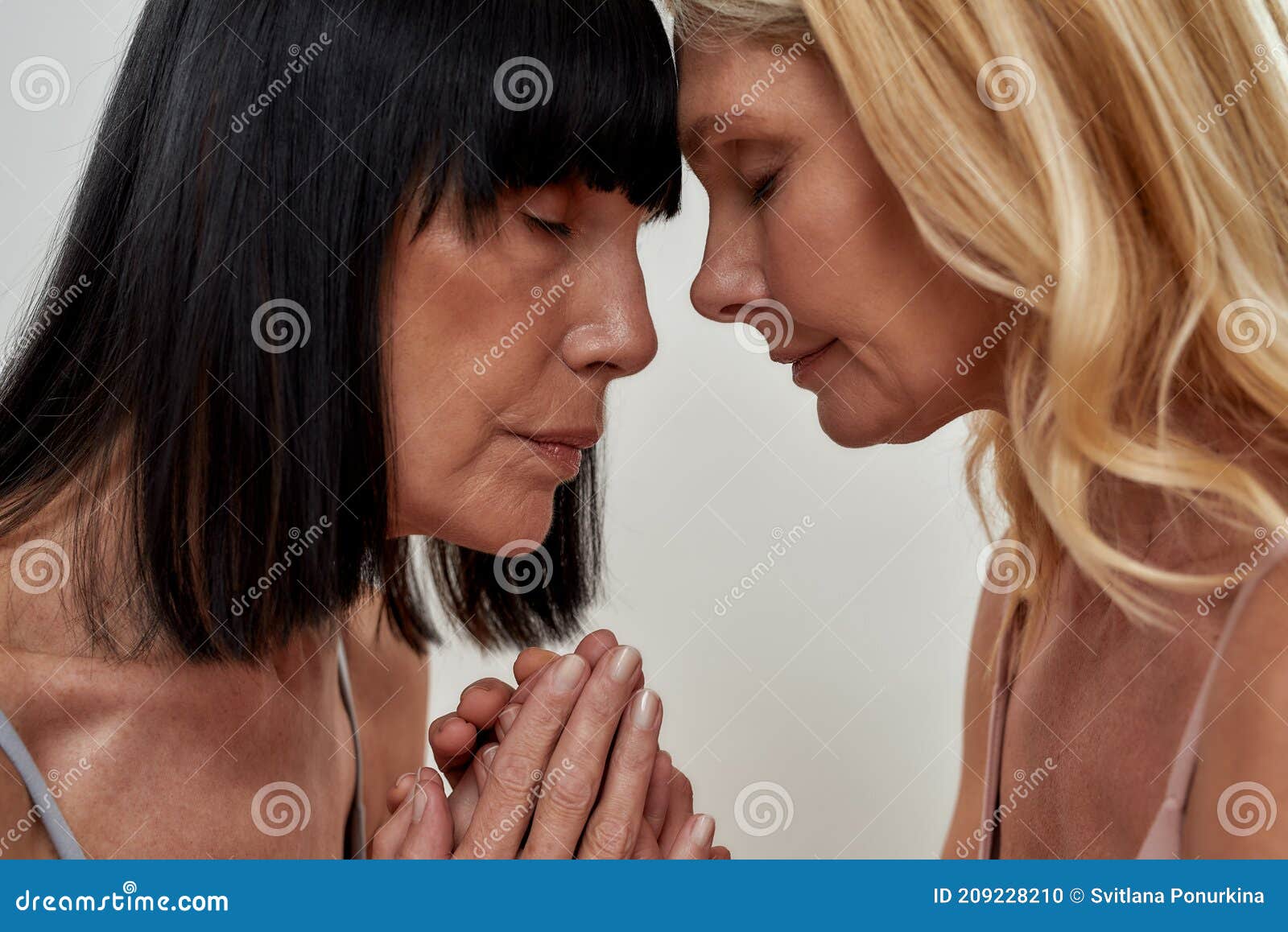 Close Up Portrait of Two Women in Underwear Holding Each Other Hands photo