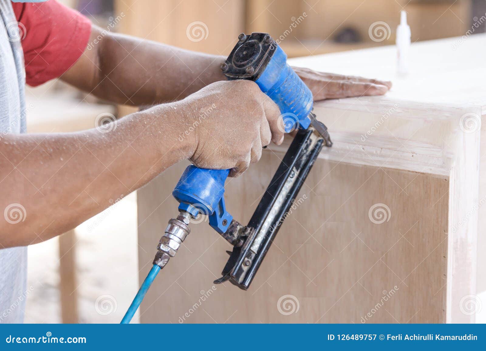 Worker at Carpenter Workspace Installing Nail Using Pneumatic Na Stock
