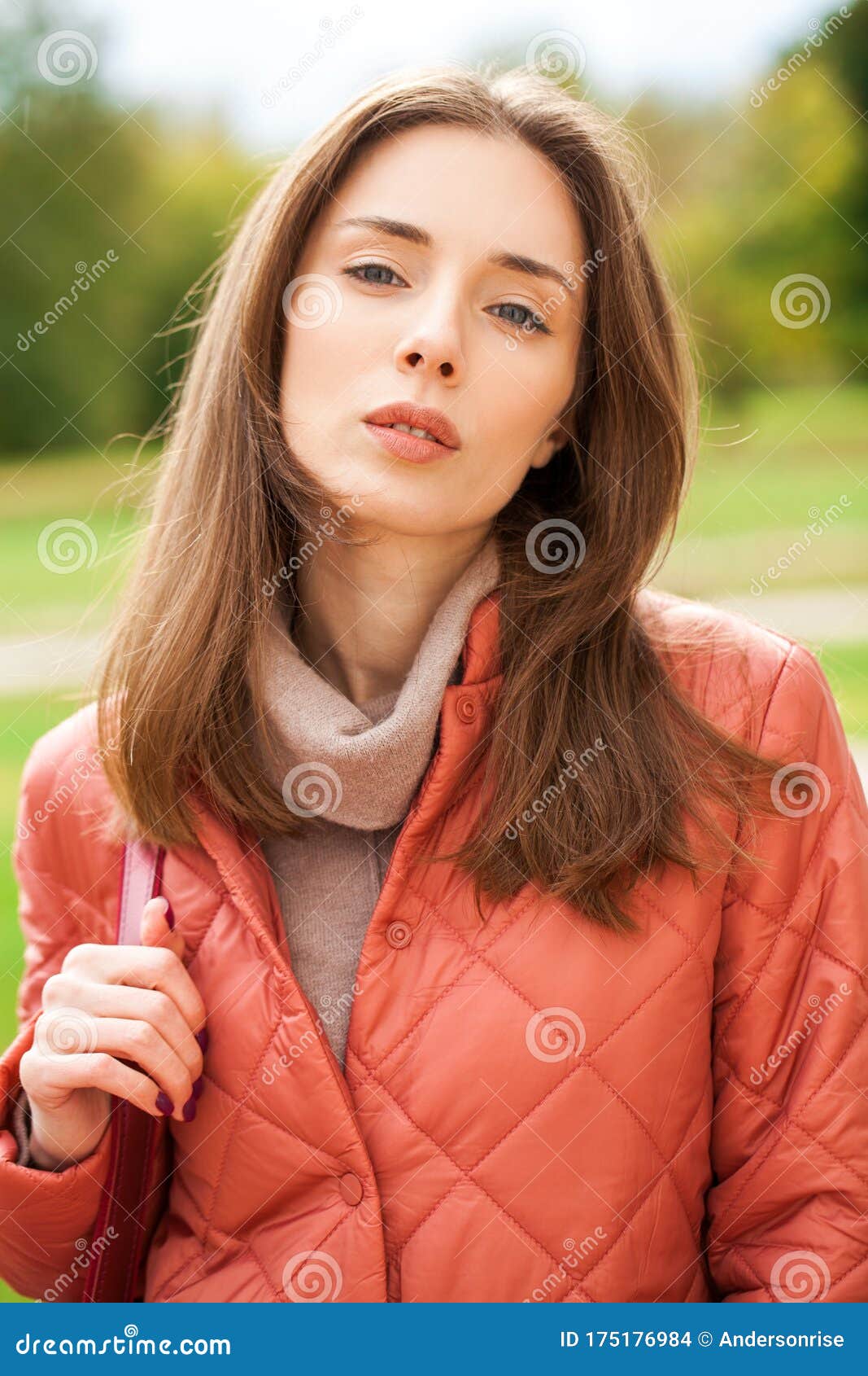 Close Up Portrait Of A Young Beautiful Brunette Girl In Coral Coat 