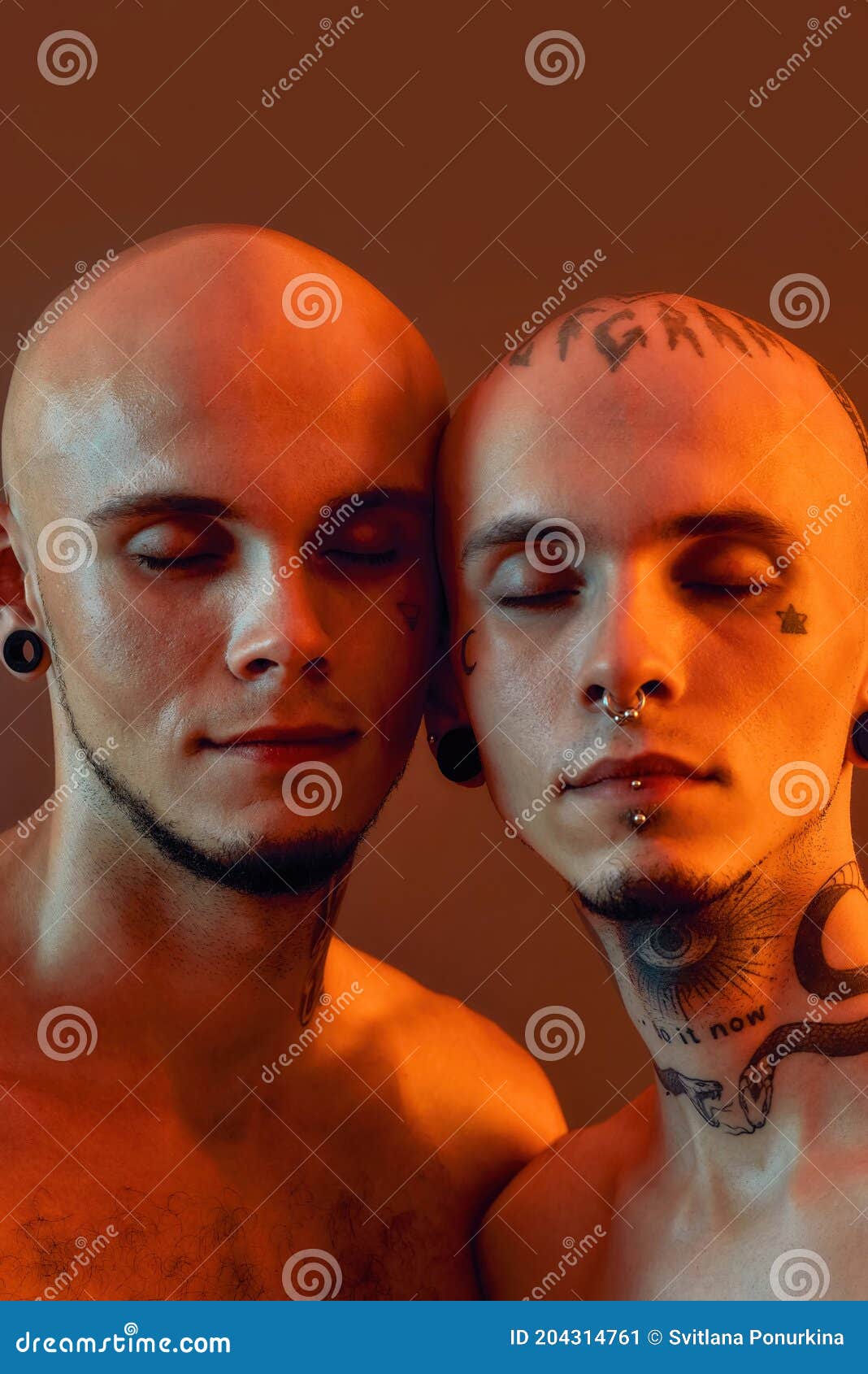 Close Up Portrait Of Young Half Naked Twin Brothers With Tattoos And Piercings Posing Together