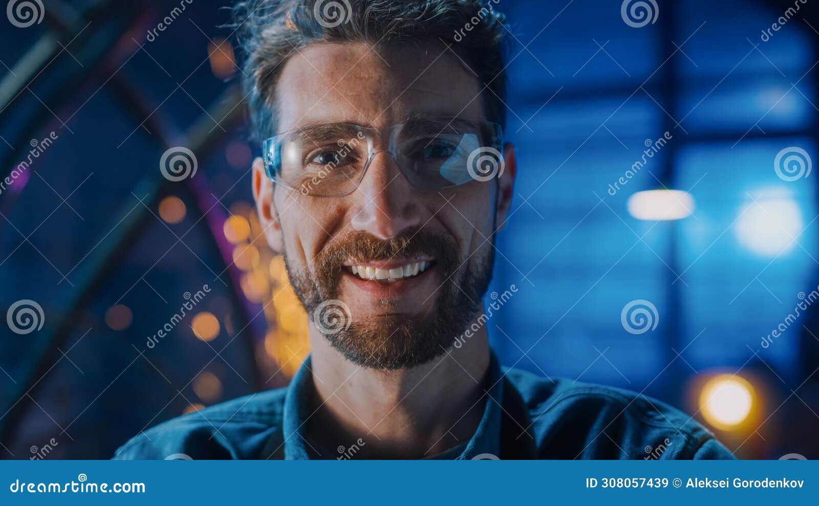 close up portrait of a young professional fabricator in safety glasses smiles at the camera. authe