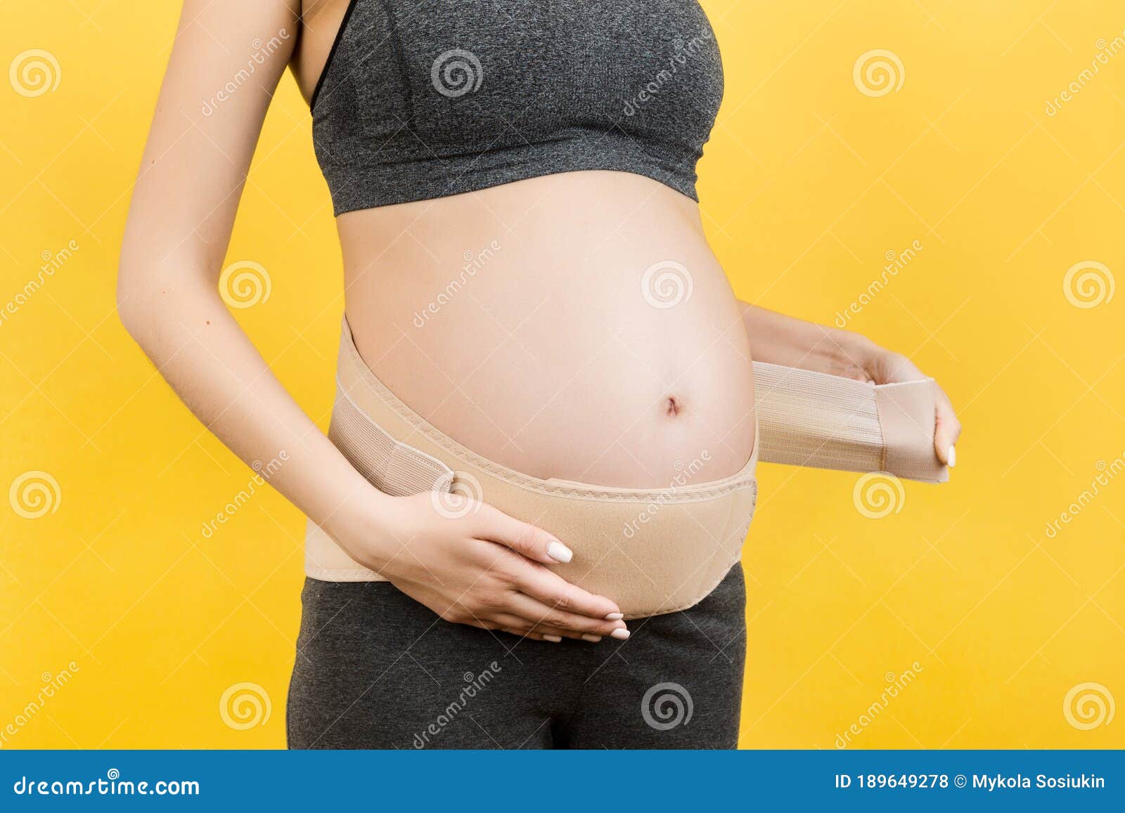 Close Up of Pregnant Woman Dressing Pregnancy Corset on the Third Trimester  at Yellow Background with Copy Space. Orthopedic Stock Photo - Image of  bandage, dressing: 189649278