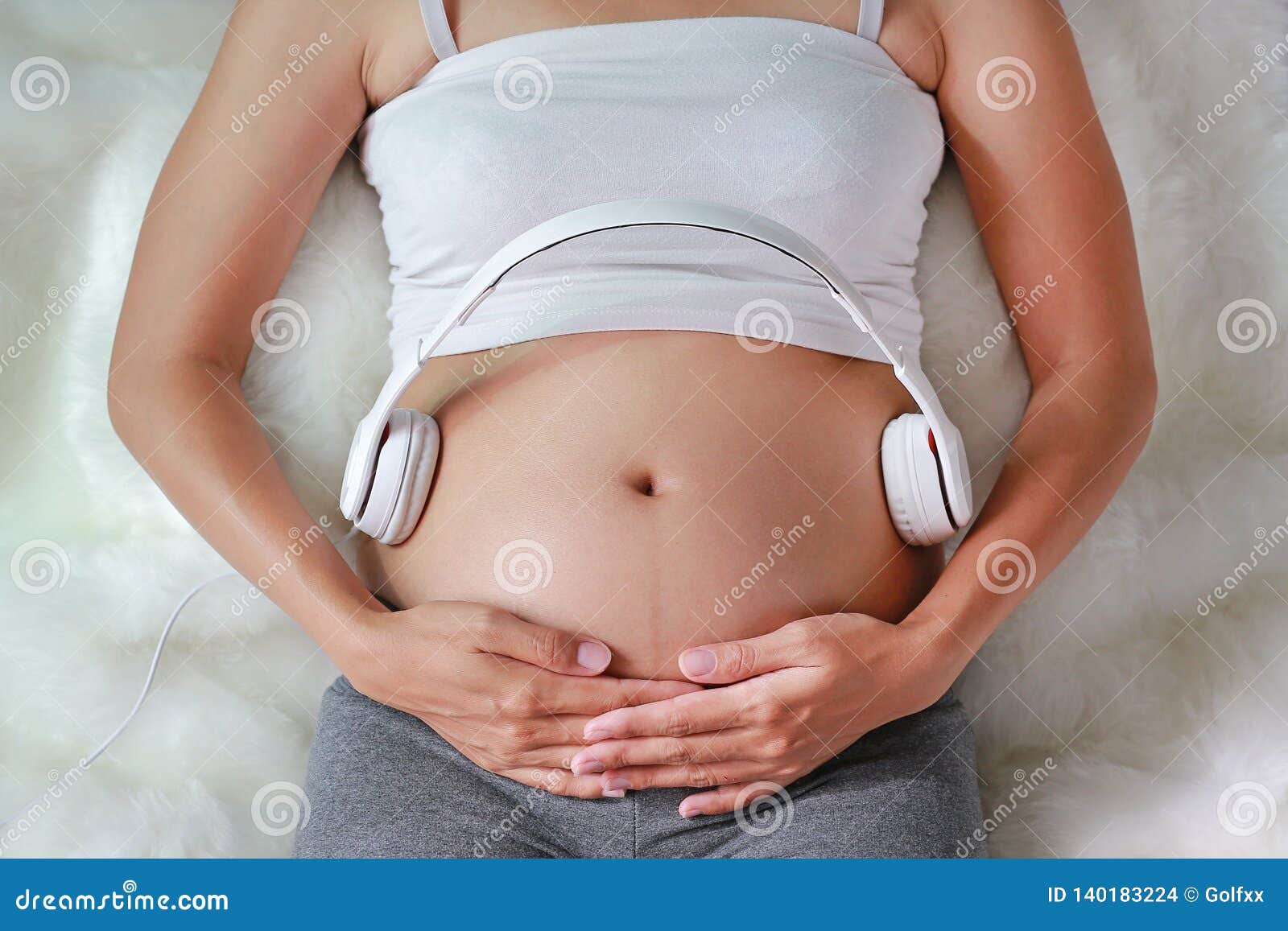 Close up of pregnant woman using headphones on her belly Stock Photo by  ©Dmyrto_Z 136380656