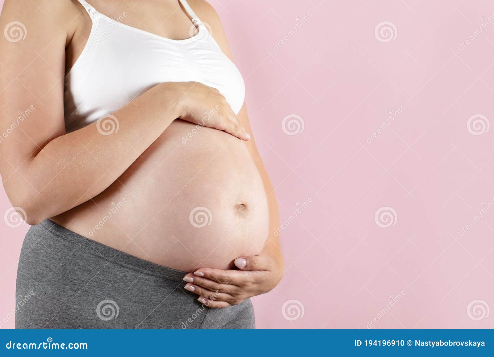 Close Up of Pregnant Woman Wearing Supportive Seamless Maternity Bra & Grey  Yoga Pants, Arms on Her Belly. Female Hands Wrapped Stock Photo - Image of  hands, maternity: 194196910
