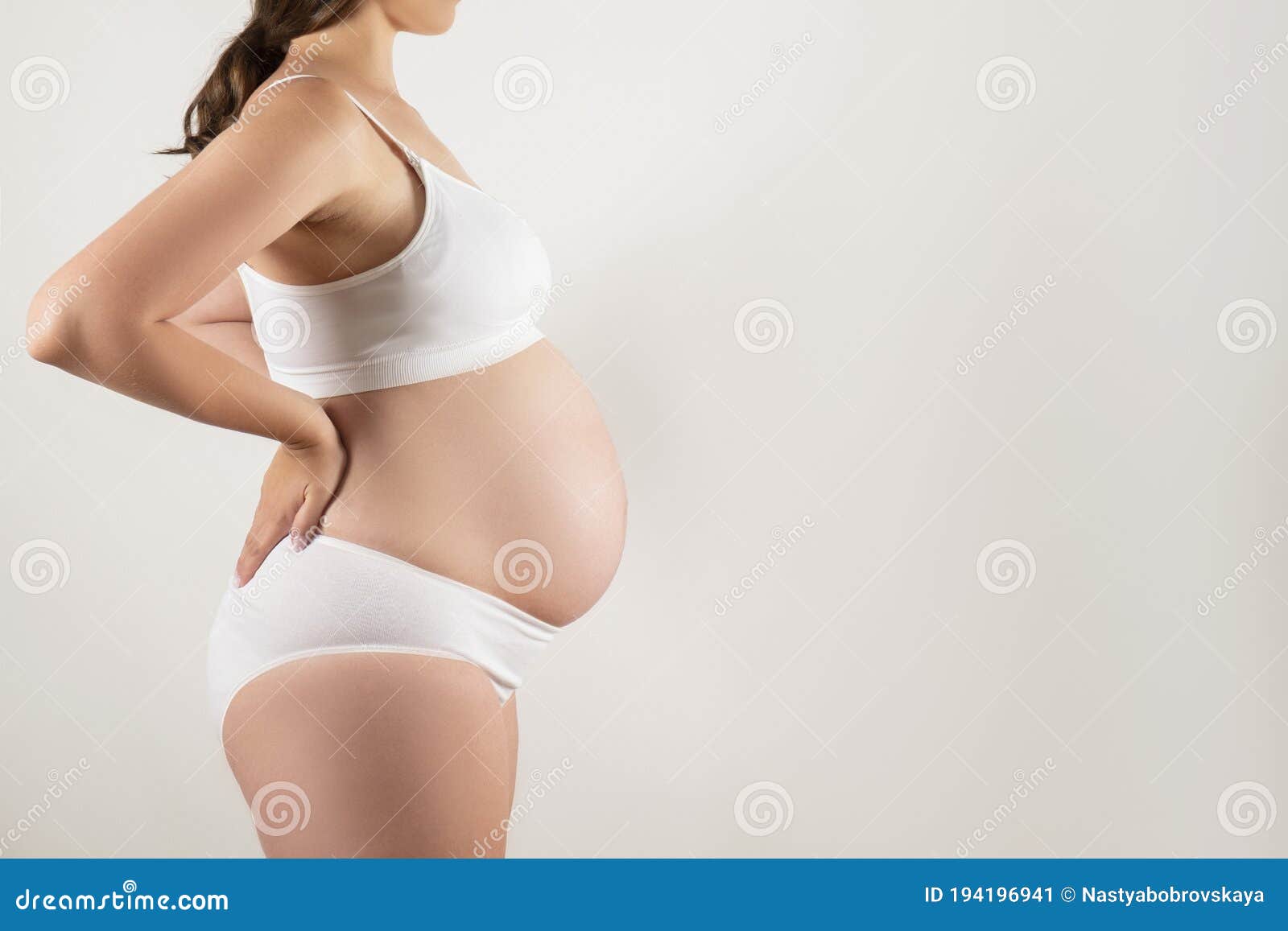 Close Up of Pregnant Woman Wearing Supportive Seamless Maternity Bra and  Maxi Bottoms, Arms on Her Belly. Female Hands Wrapped Stock Image - Image  of child, health: 194196941