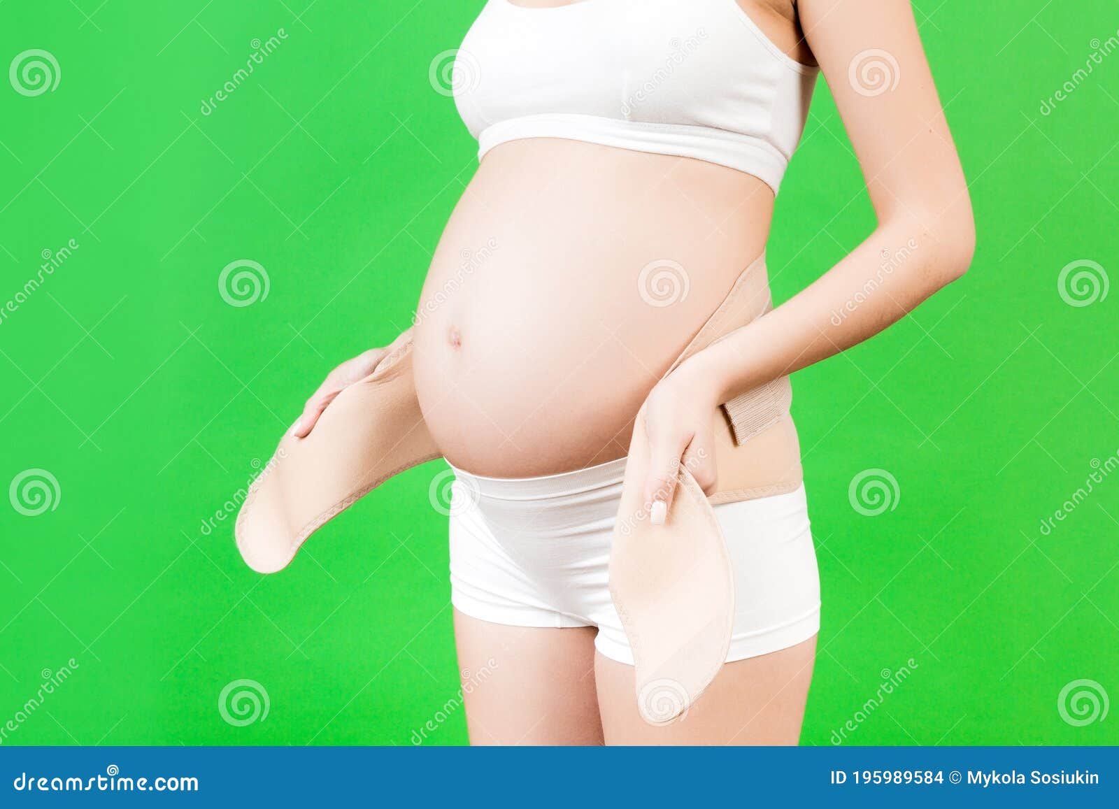 Close Up of Pregnant Woman in White Underwear Putting on a Bandage