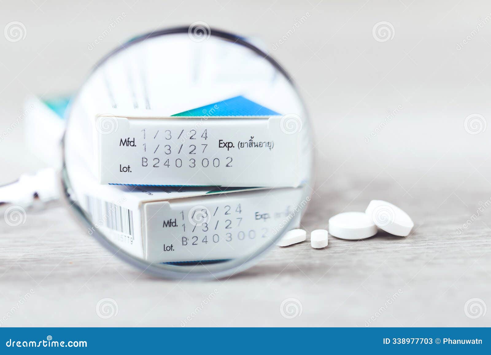 close-up of the production code and expiration date printed on the side of a medicine box, with pills placed on a table. the image