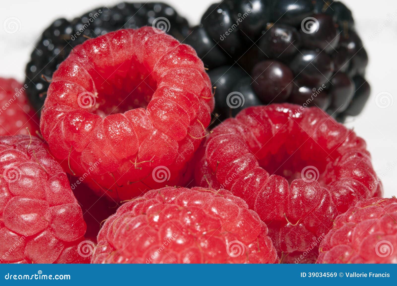 Macro Raspberries and blackberries. A close up of raspberries in the foreground, and blackberries in the background