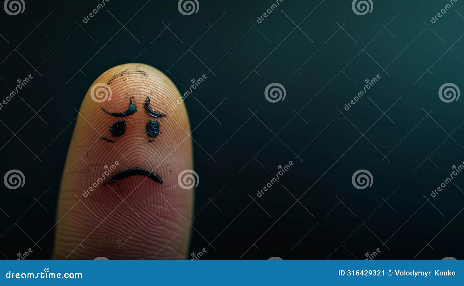 close-up of a sad face drawn on a fingertip
