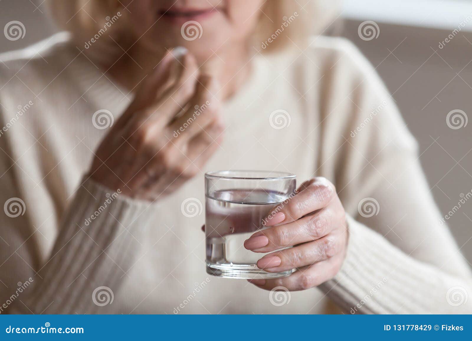 close up of senior woman feeling unwell taking pill