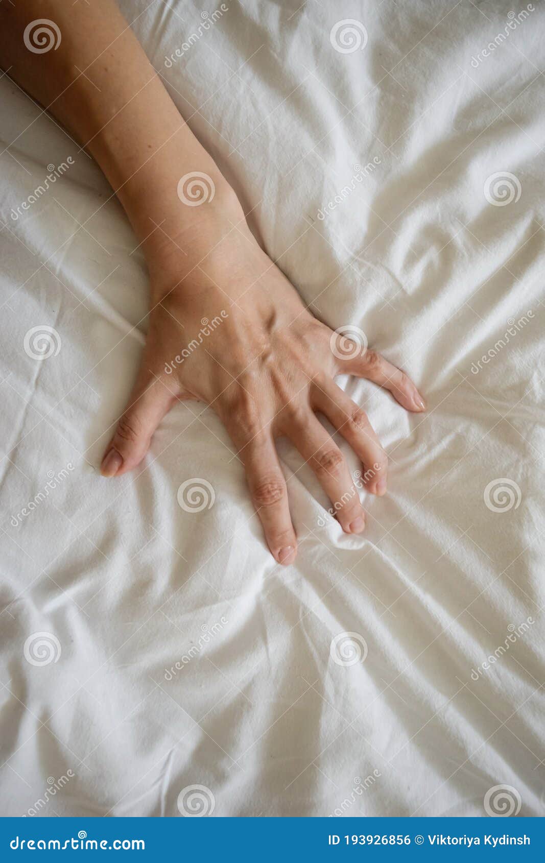 Close Up Woman Hand Pulling and Squeezing White Sheets in Ecstasy in photo picture