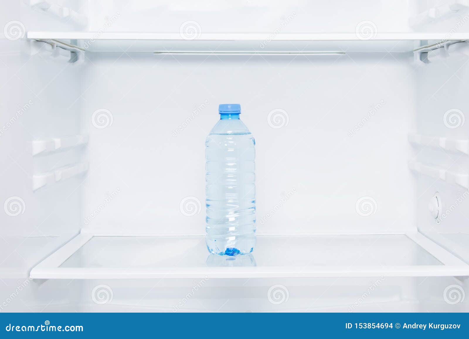 Closeup, Shelves of White Refrigerator and a Bottle of Water Stock