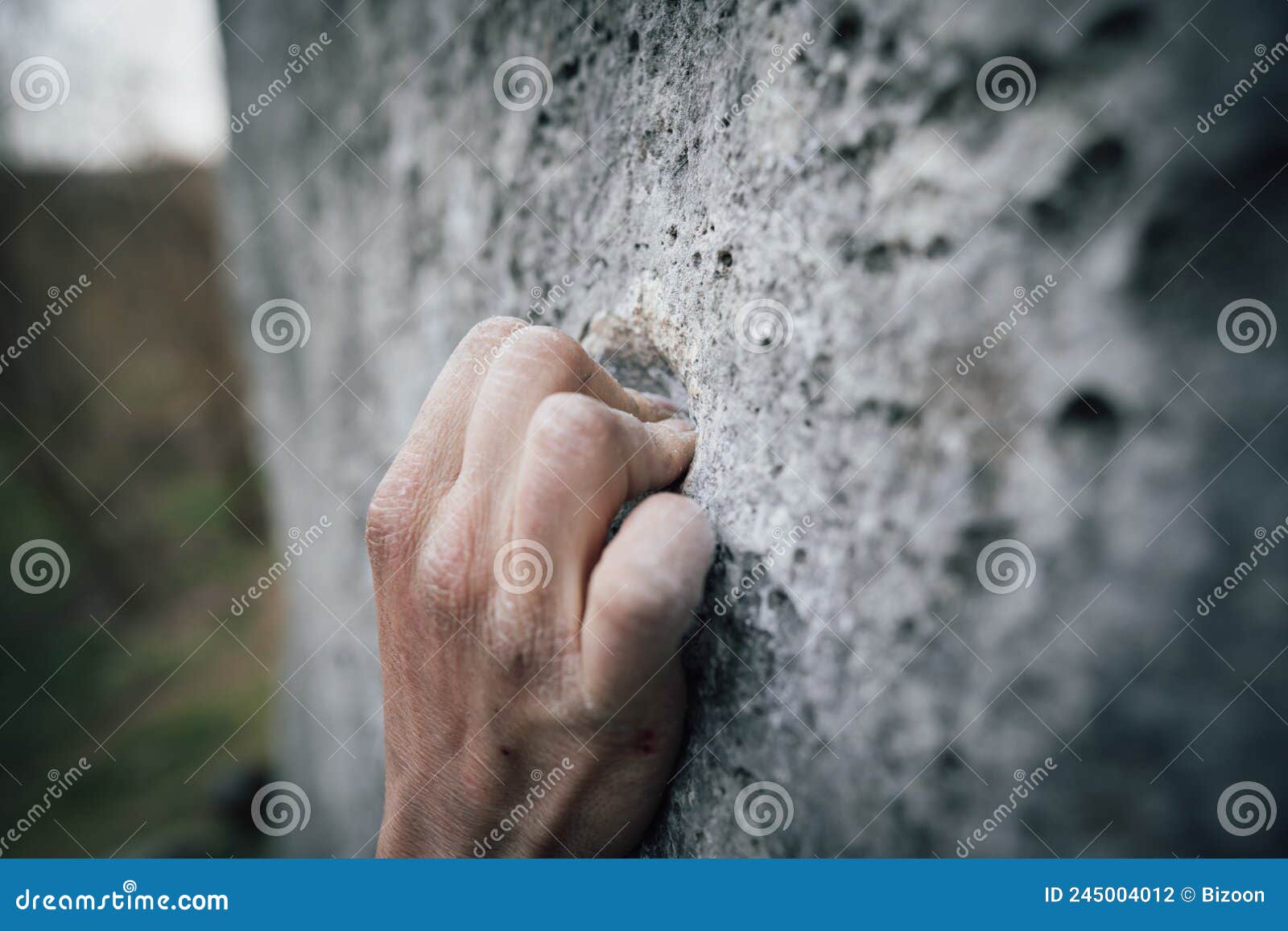 adult male handholding on to a rock