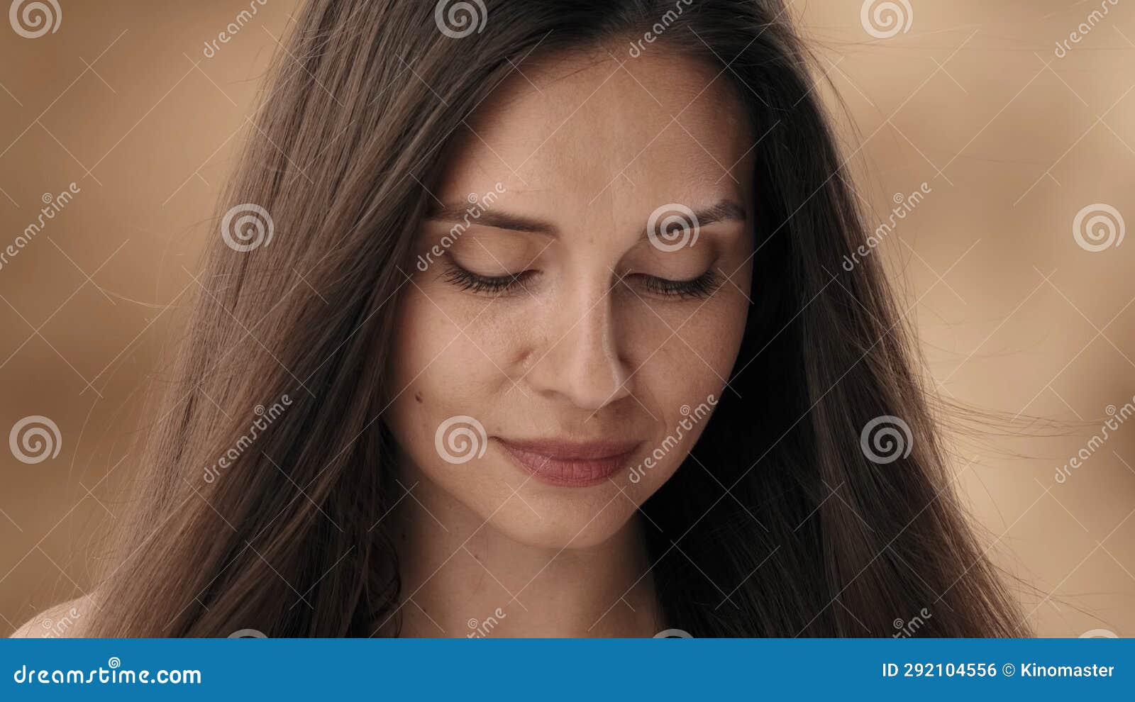 In A Close Up Shot Of A Middle Aged Attractive Woman With Dark Straight Hair She Tilts Her