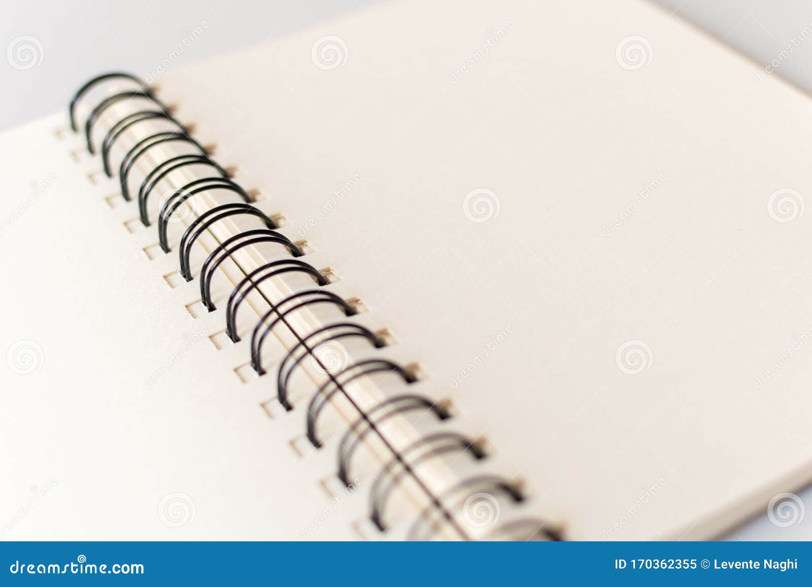 close up shot of an open blank sketchbook placed on a light gray table.
