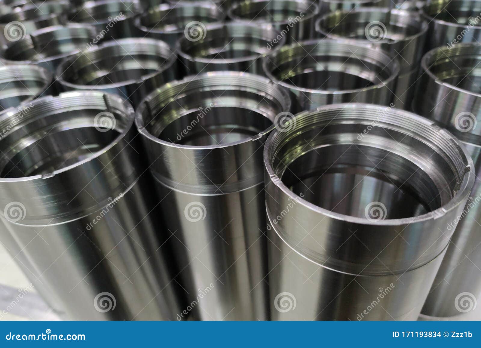 a close-up shot of shiny steel aerospace cnc turned tubes in a batch with selective focus and background blur