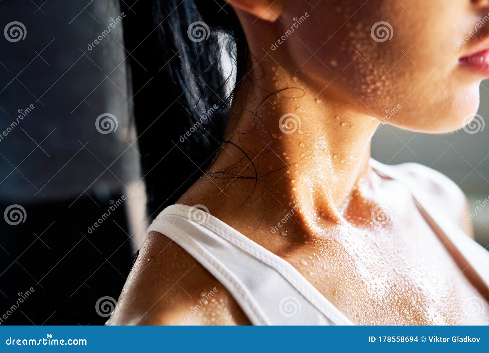 close up shoulders and neck of sporty girl in drop of sweat on skin after workout