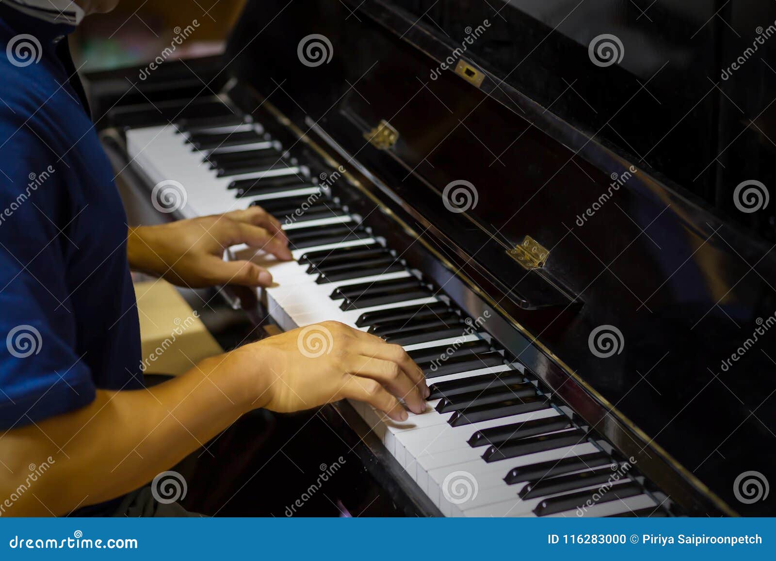 Close Up Side View of Man Hands Playing Piano with Blurry Background