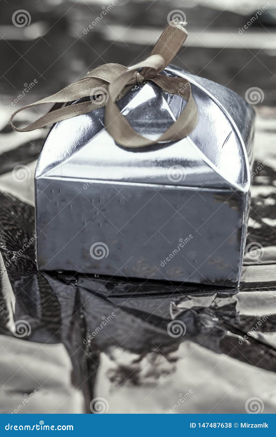 Close Up of a Small Gift Box Cover with Silver Shiny Paper on Brownish