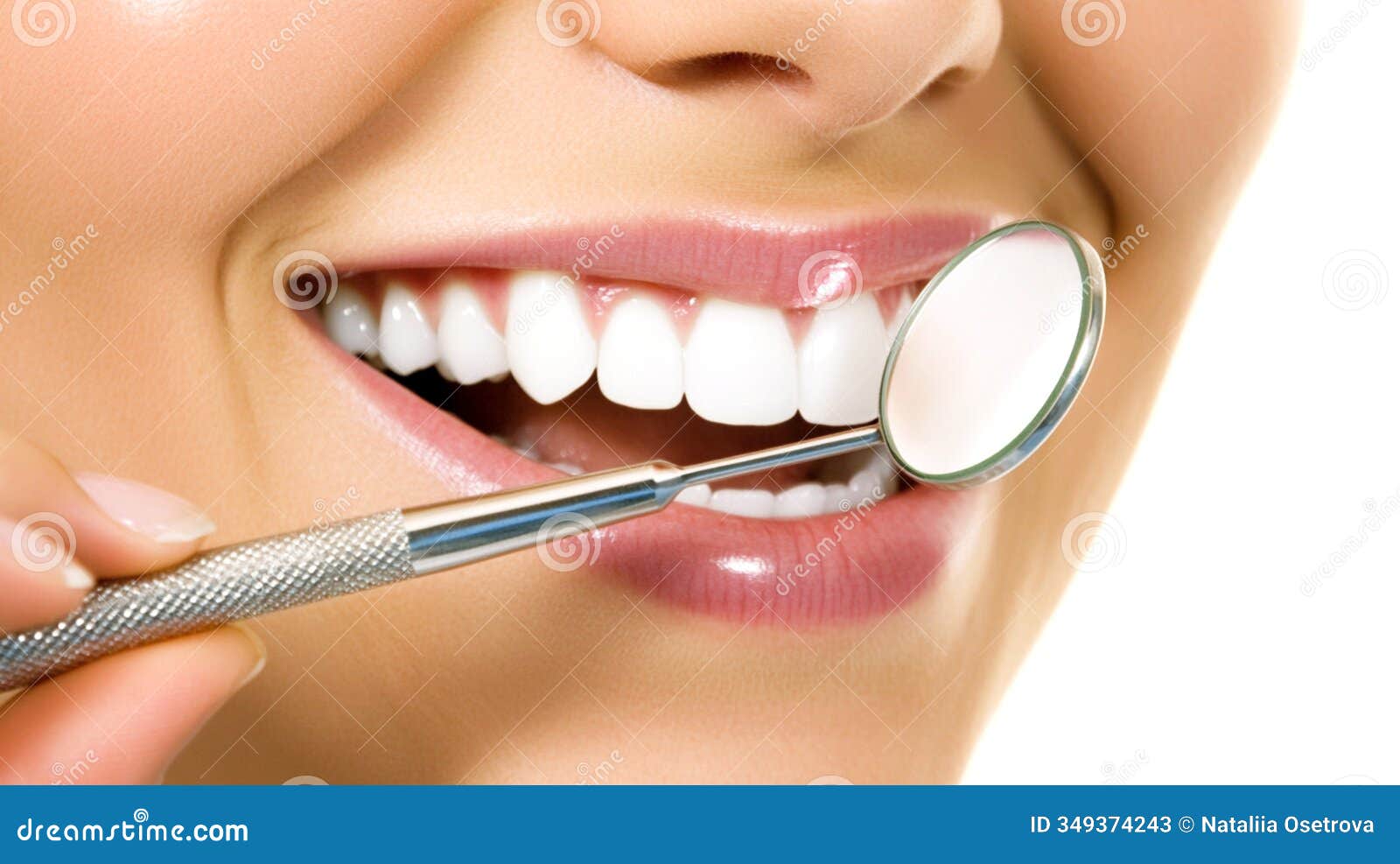 close-up of a smiling woman with perfectly white teeth during a dental checkup using a dental mirror. close-up