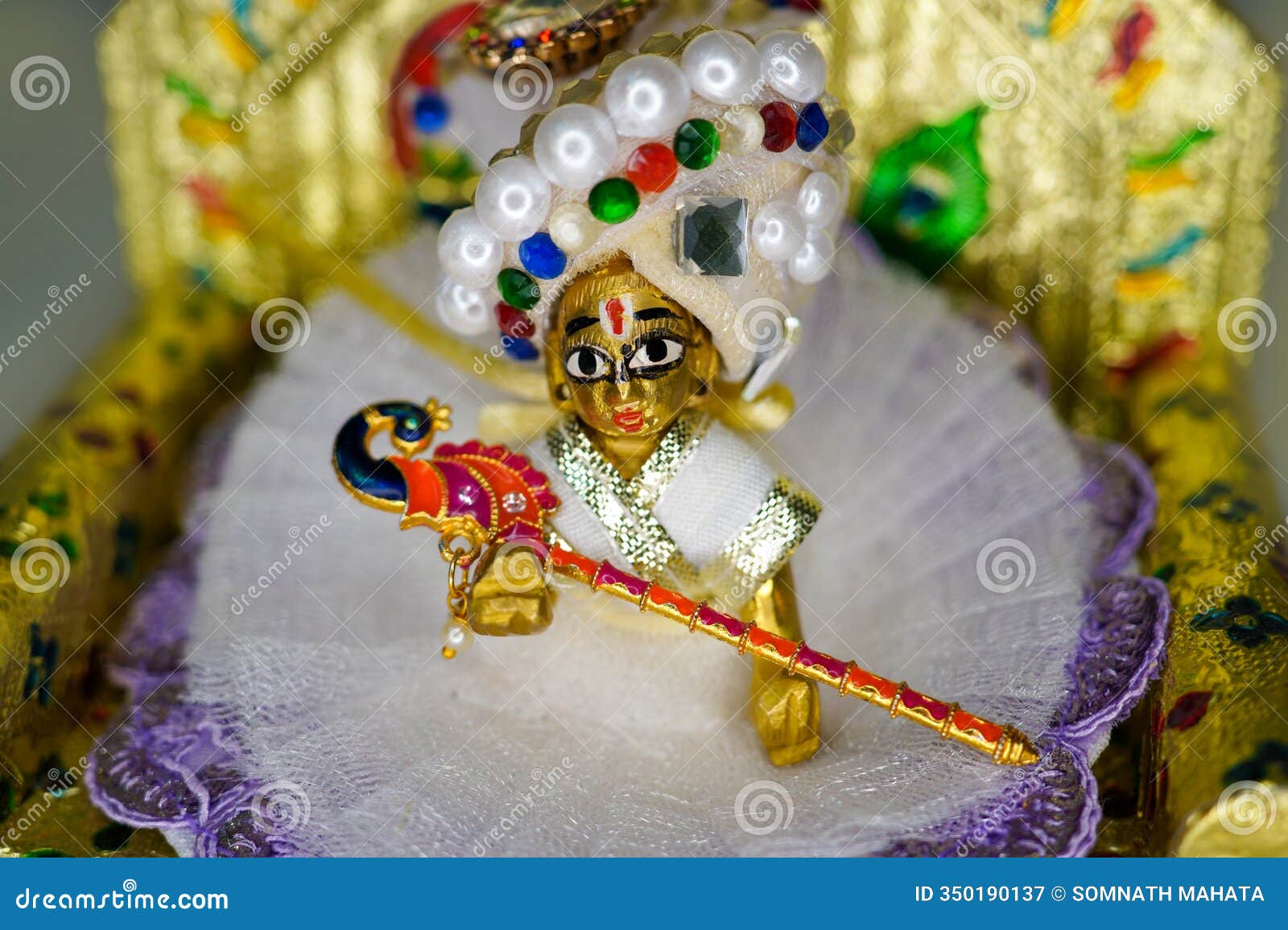 close up on statue of hindu god lord krishna also known as bal gopal sitting on his throne on janmashtami festival. selective