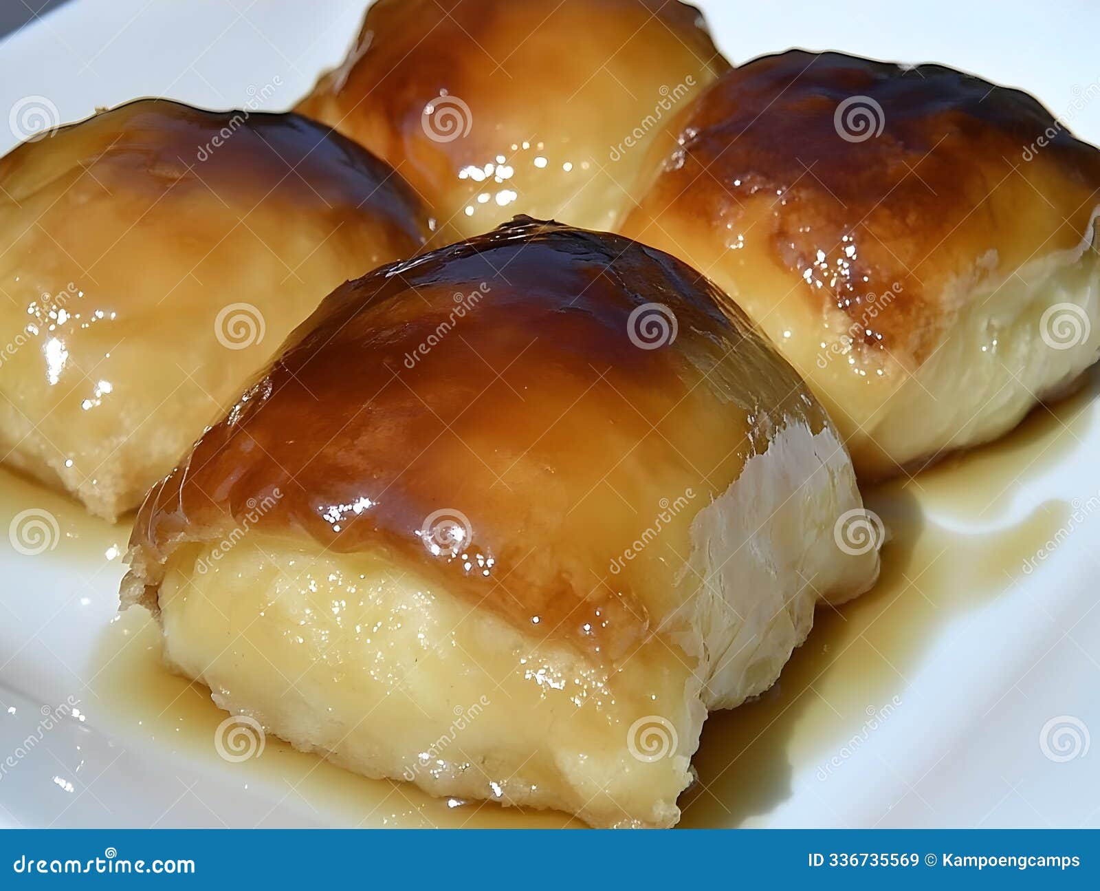 a close-up of sweet, glossy pastries drizzled with syrup on a plate