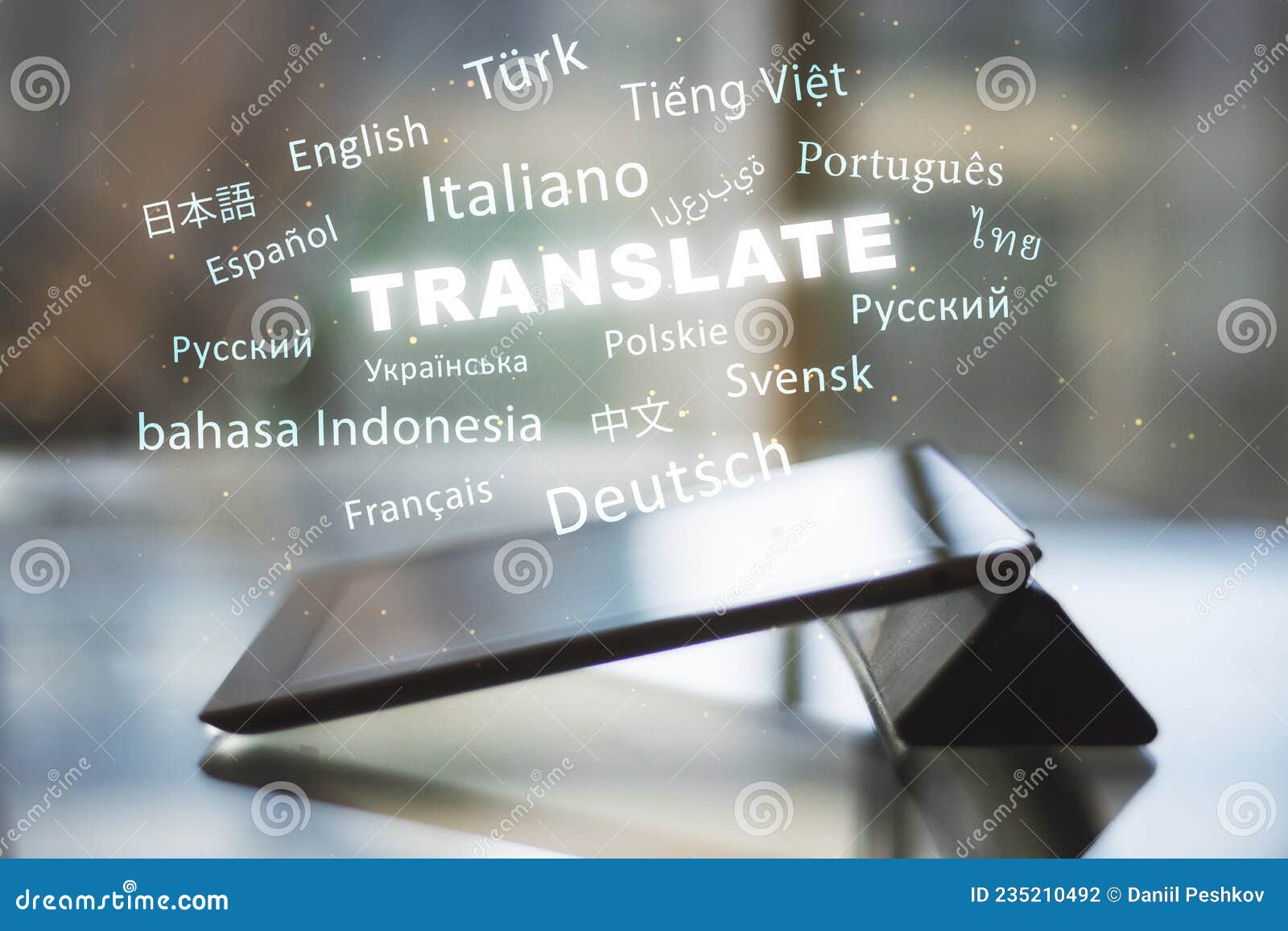 Close Up of Tablet with Abstract Text on Blurry Background. Translation