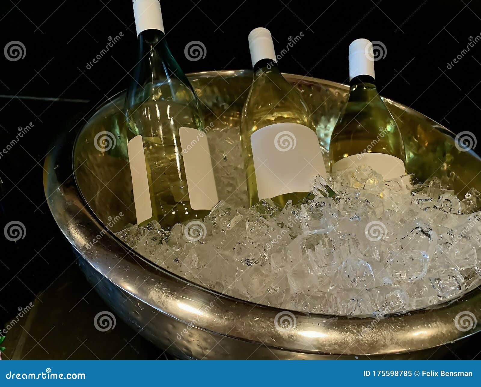 Three Bottles of White Wine Cooling in a Bucket of Ice Stock Image