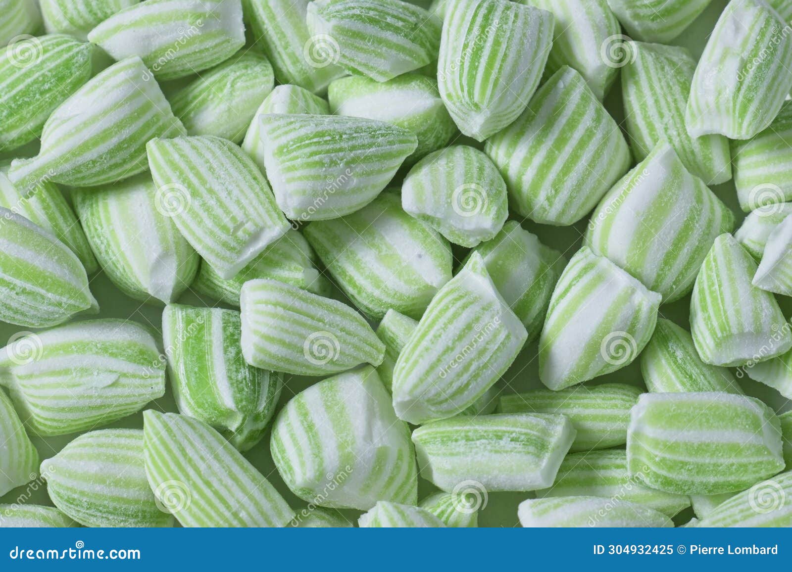 Close Up Top View of a Pile of Green and White Striped Mint Candy Stock