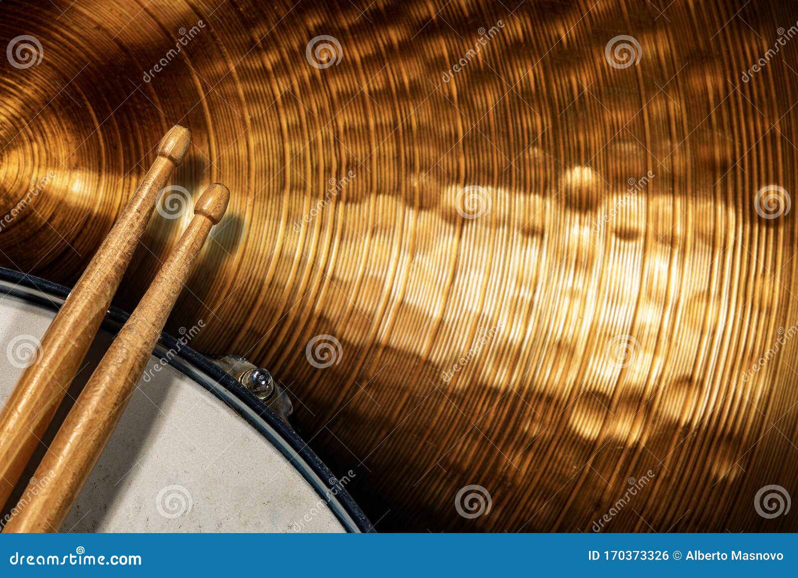 two wooden drumsticks on a snare drum and golden cymbal - percussion instrument