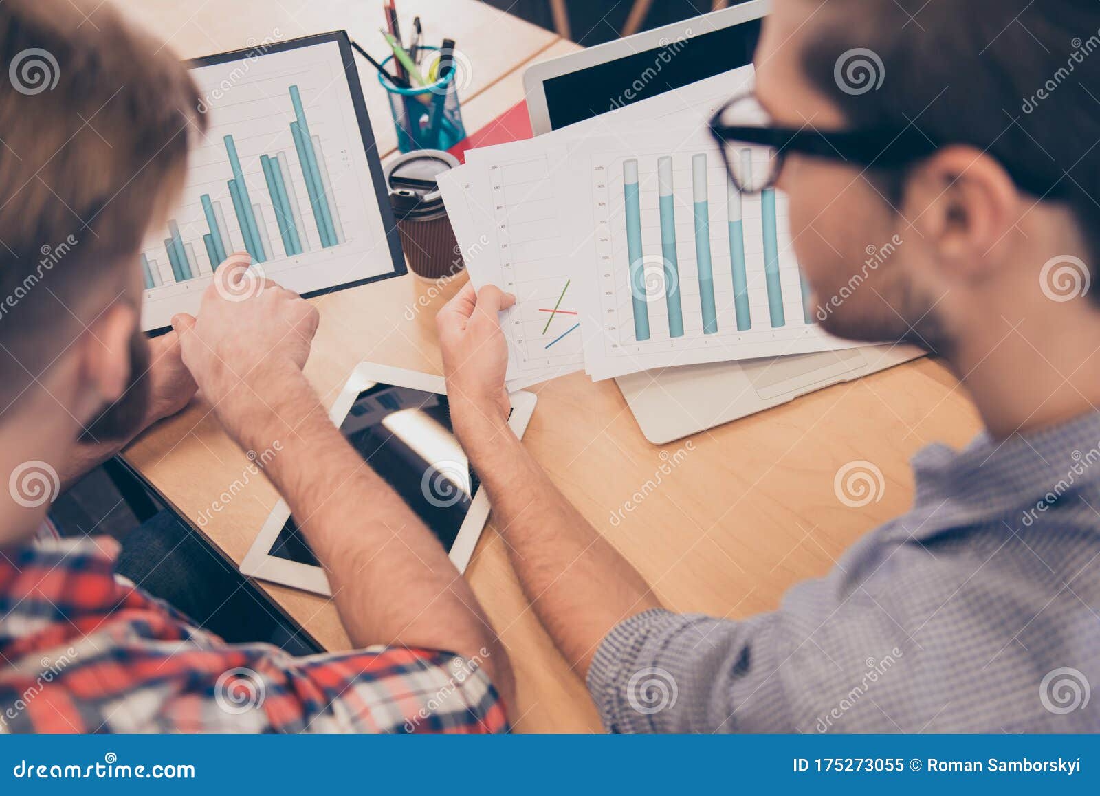 close up of two young managers expertising diagrama of financial growth