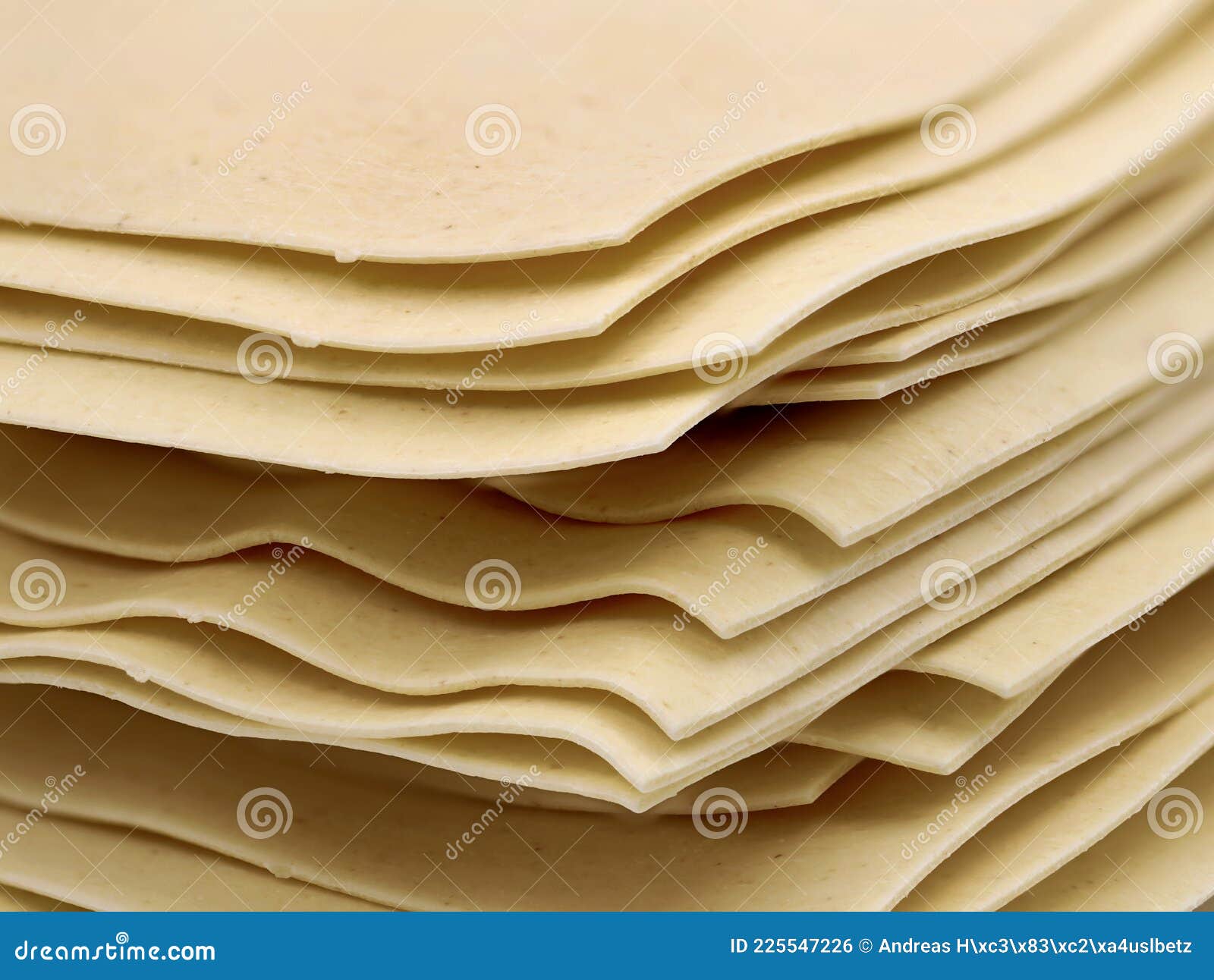 close up of uncooked stacked lasagne sheets  on white background
