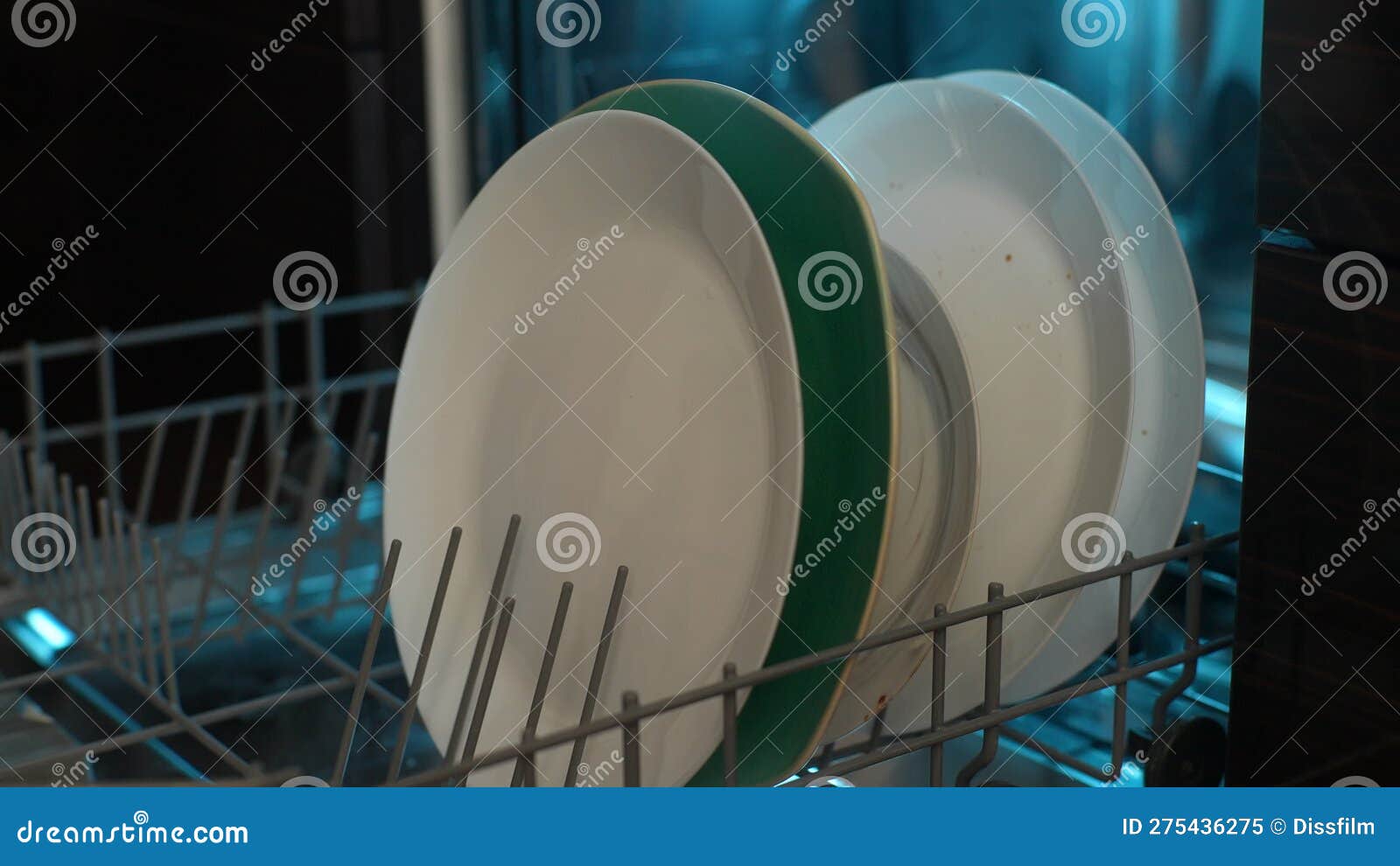 Closeup of Unrecognizable Man Loading Far Shelf of Dishwasher Machine
