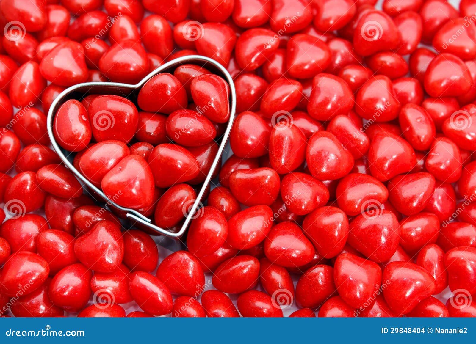 Roodgloeiend hartsuikergoed. Close-up van hart gevormde koekjessnijder die door roodgloeiend suikergoed wordt omringd
