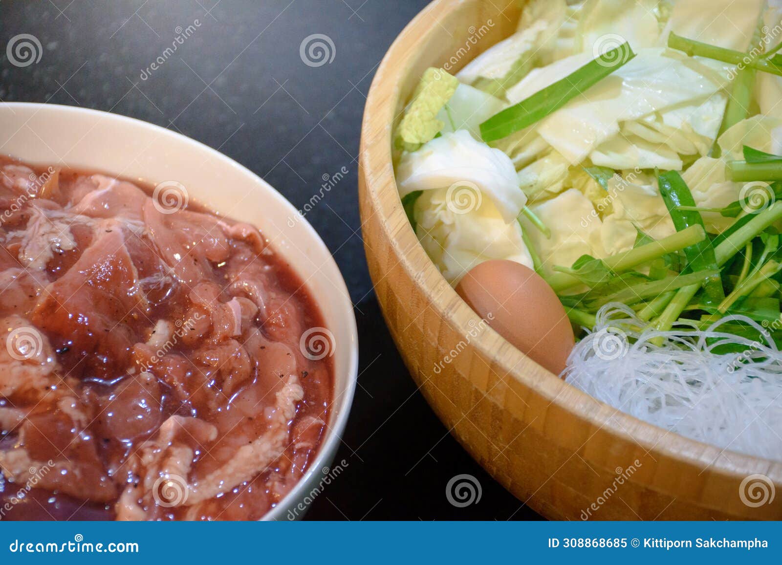 close-up various vegetables with egg and marinated meat in a bowl used as a barbecue ingredient in korean bbq buffet in thai