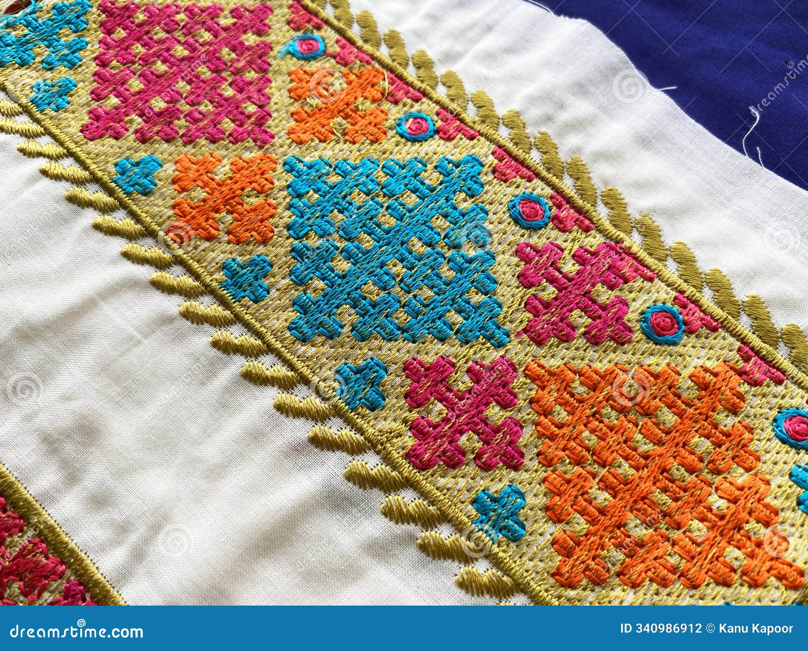 close up view of intricate multi colored geometric thread embroidered border