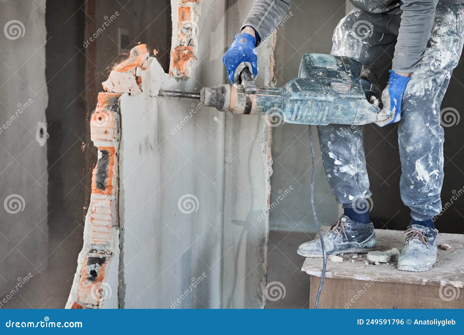 cropped view workman with perforator during demolition wall.
