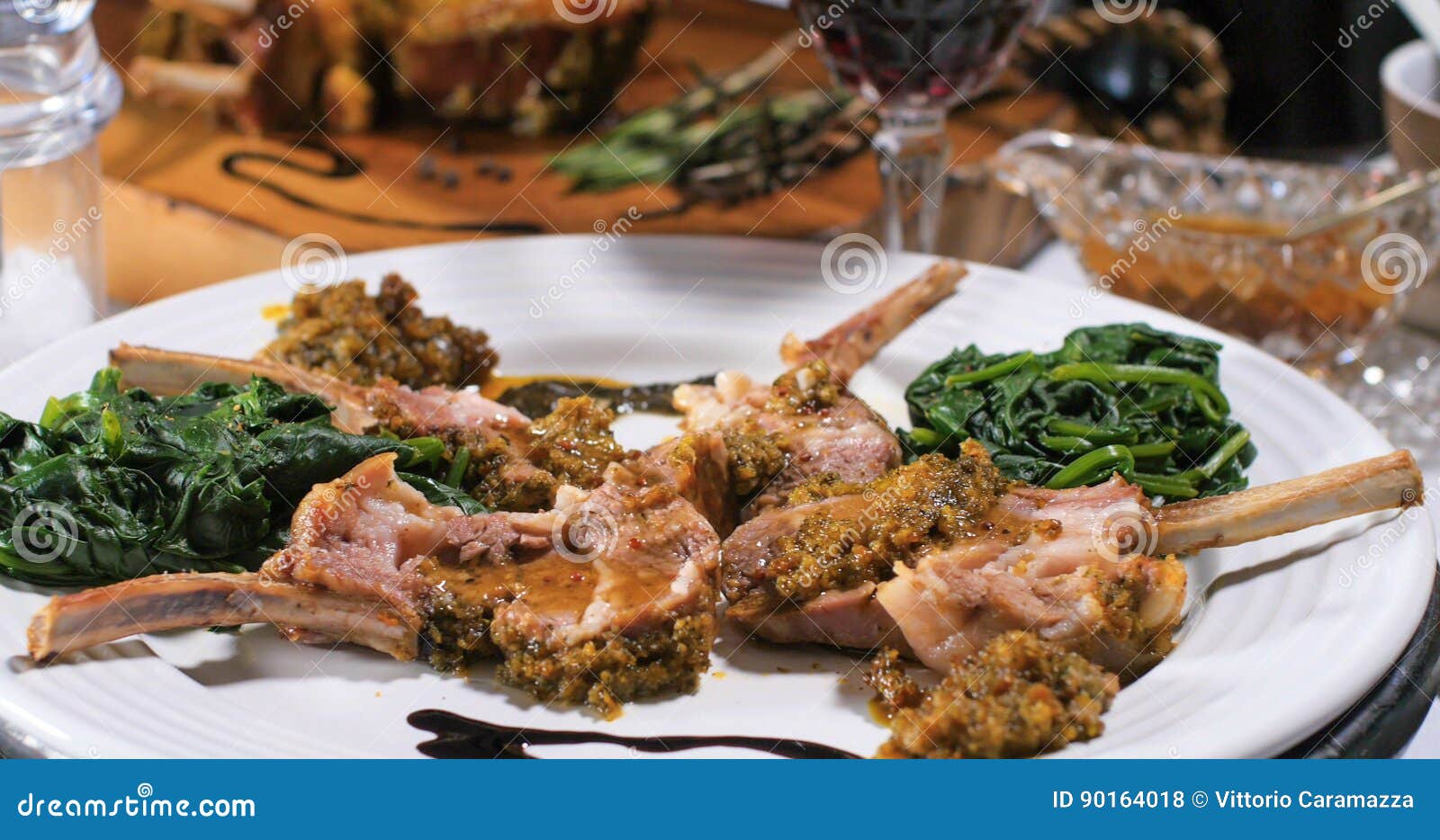 Close Up View of a Rack of Lamb with Mint Sauce and Spinach Stock Photo