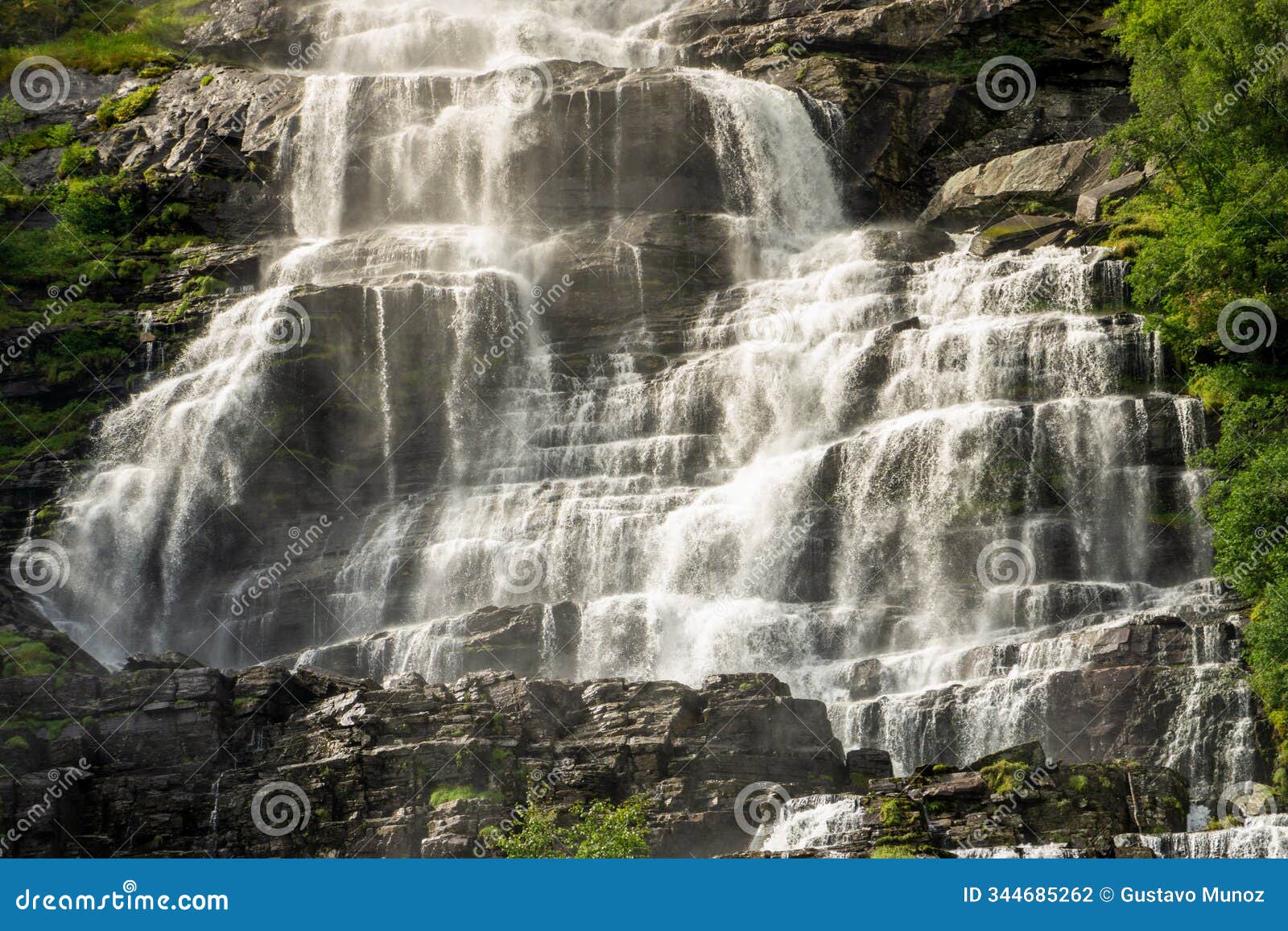 close-up view of tvindefossen waterfall in voss, norway, showing sunlit water cascading over layered rock formations