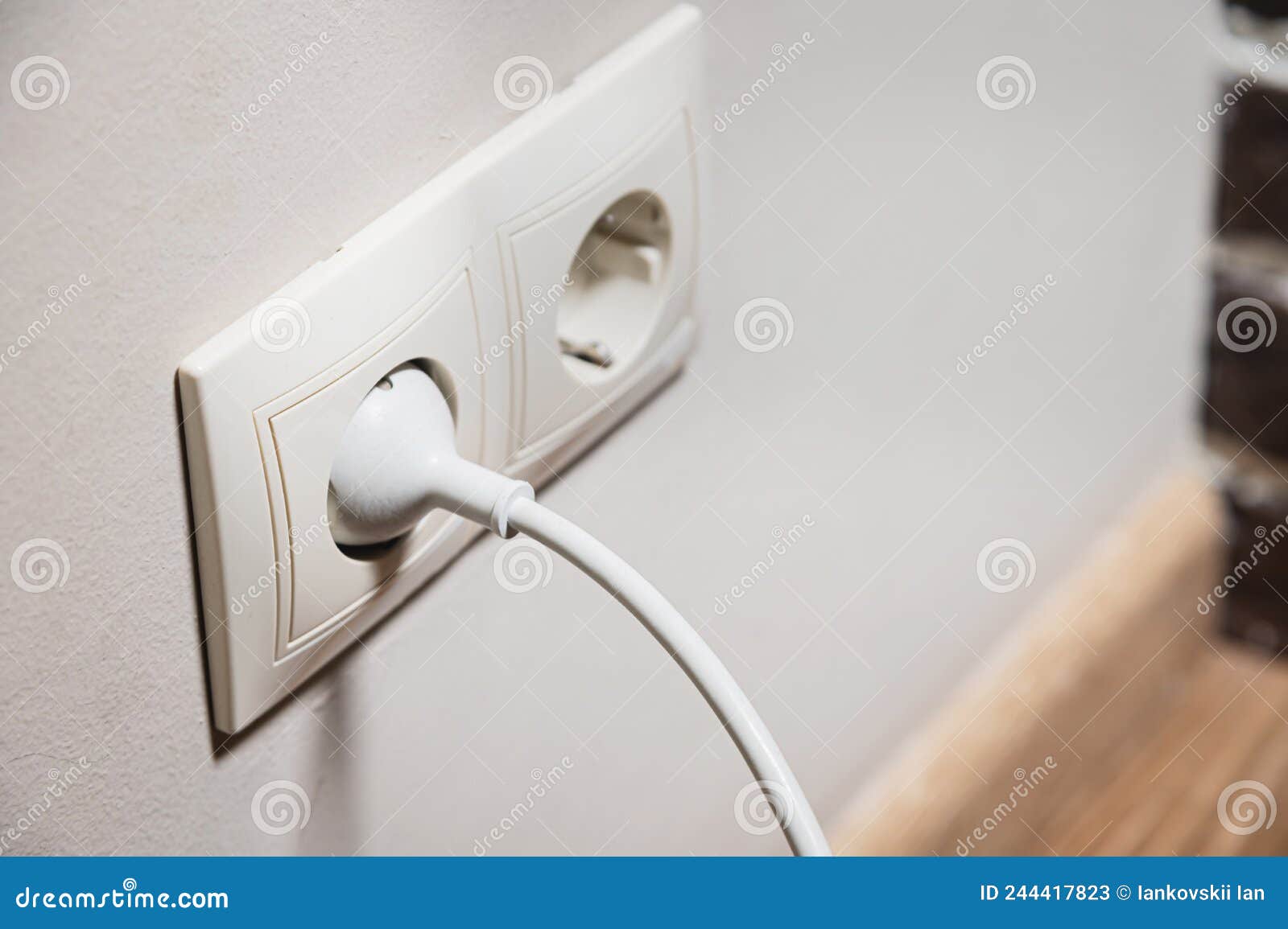 Closeup of a White Electric Plug in a 220 Socket in the Wall. Power on