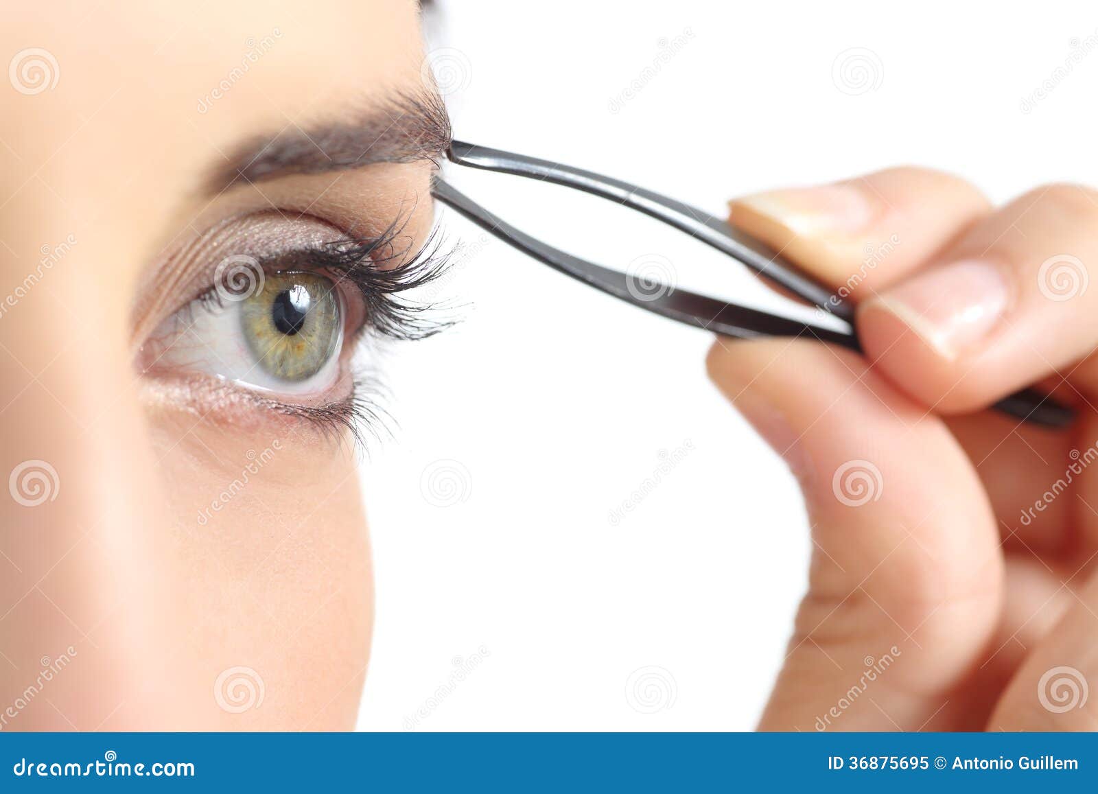 close up of a woman eye and a hand plucking eyebrows