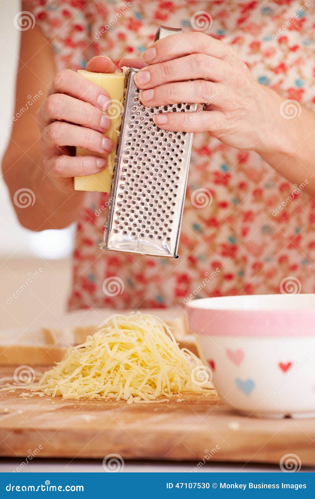 close up of woman grating cheese in kitchen